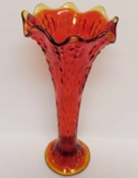 A red glass vase with a yellow rim

AI-generated content may be incorrect.