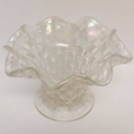 A clear glass vase with a wavy edge

AI-generated content may be incorrect.