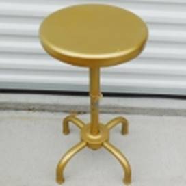 A round gold stool on a white surface

AI-generated content may be incorrect.
