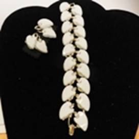 A bracelet and earrings on a black velvet surface

AI-generated content may be incorrect.