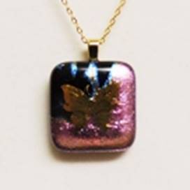 A purple and gold pendant with a butterfly on it

AI-generated content may be incorrect.