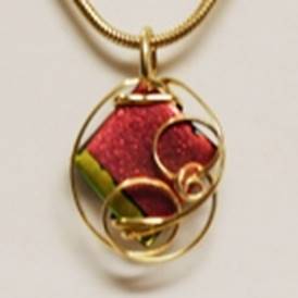 A gold necklace with a red and green square pendant

AI-generated content may be incorrect.