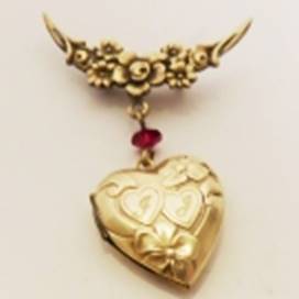 A gold heart shaped locket with a red gem

AI-generated content may be incorrect.