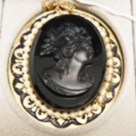 A black cameo with a gold border

AI-generated content may be incorrect.